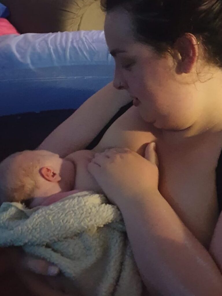 a mother breastfeeding her baby who she has just given birth to